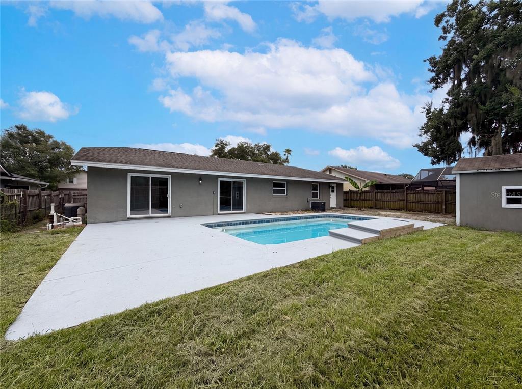 The backyard features a swimming pool, a concrete patio, and a grey house exterior — 963 SEQUOIA DRIVE, WINTER SPRINGS, FL