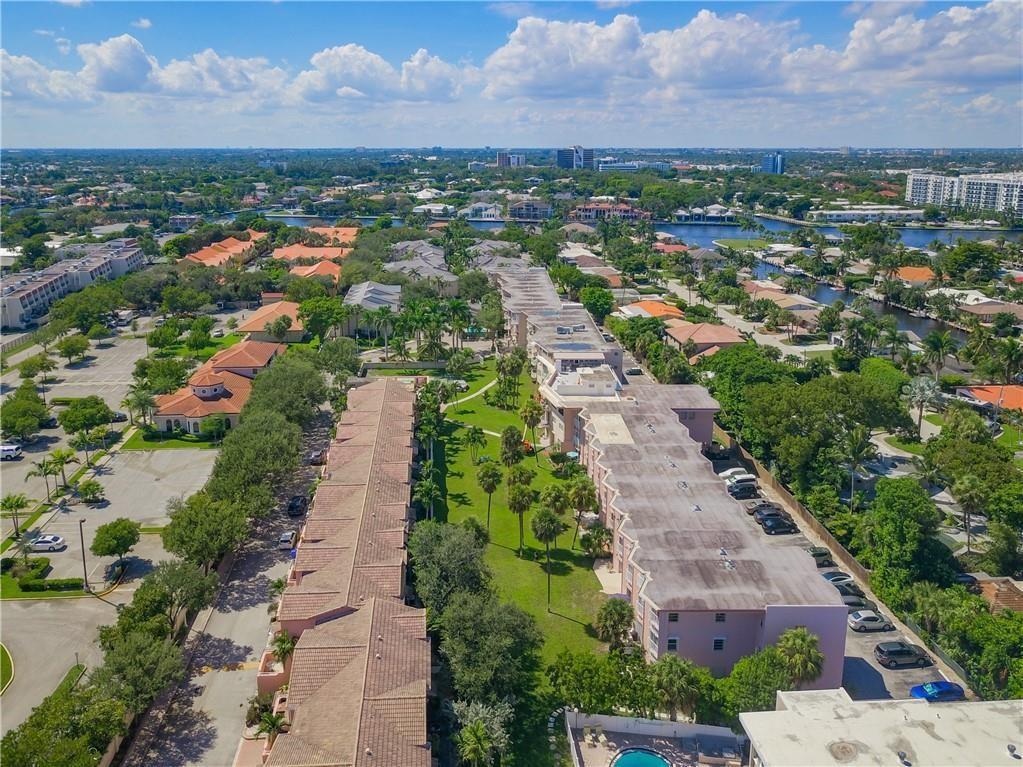 An aerial view shows multi-story residential buildings with parking lots and green spaces in Florida — 1967 S Ocean Boulevard # D, Pompano Beach FL 33062, POMPANO BEACH, FL