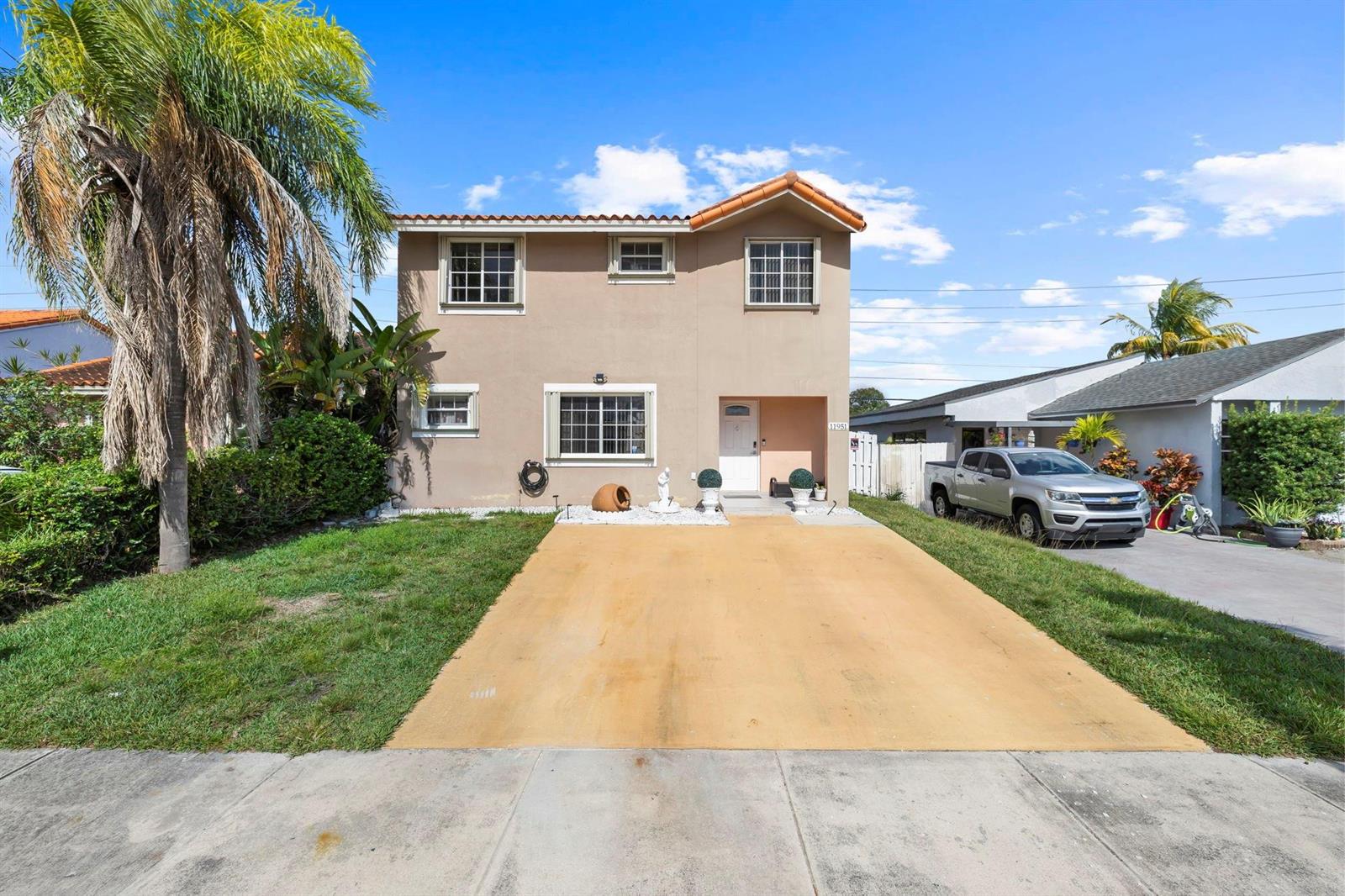 A two-story beige house with a concrete driveway and a palm tree in the yard — 11951 SW 208th Terrace, Miami FL 33177, MIAMI, FL