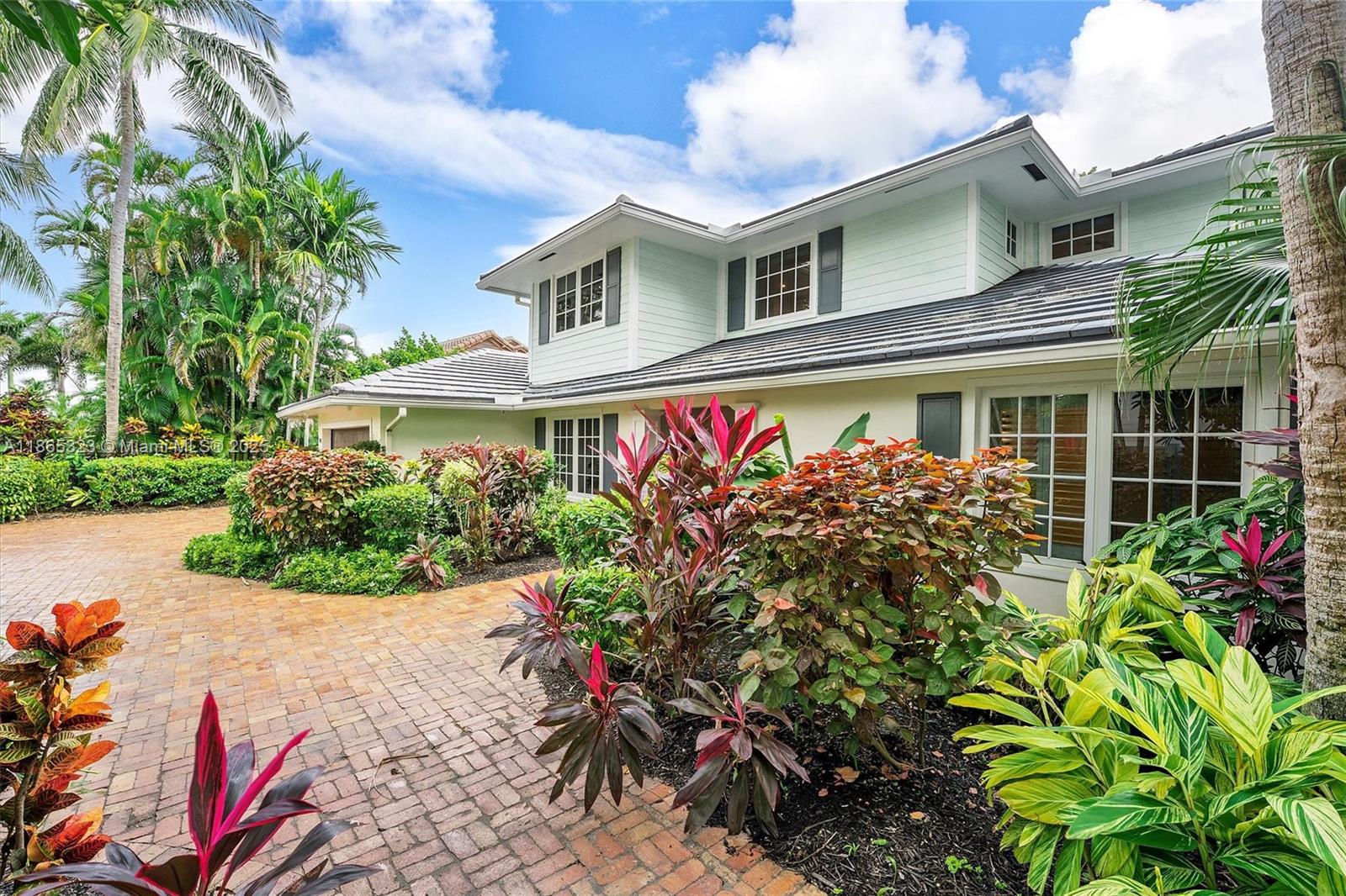 A two-story house with light green siding and a brick driveway surrounded by tropical landscaping — 746 Marble Ct, Boca Raton FL 33432, BOCA RATON, FL