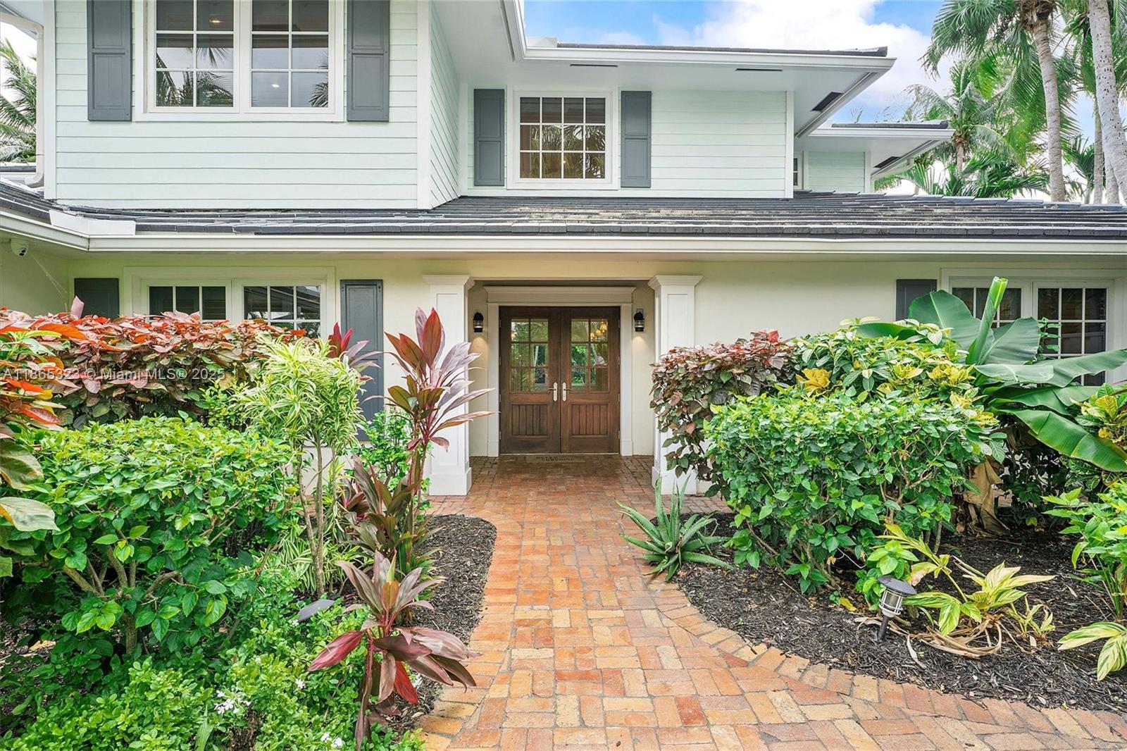 A brick walkway leads to the double wooden front doors of a two-story house — 746 Marble Ct, Boca Raton FL 33432, BOCA RATON, FL