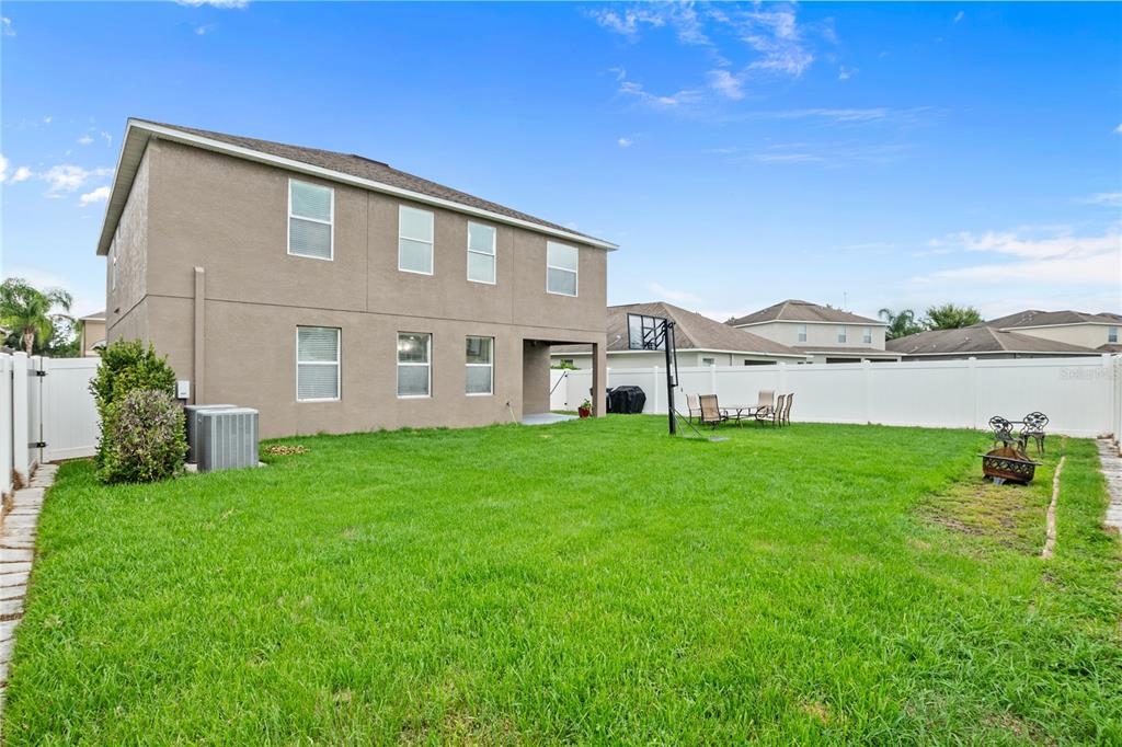 The exterior of a two-story house with a fenced backyard and a basketball hoop — 13161 ROYAL PINES AVENUE, RIVERVIEW, FL
