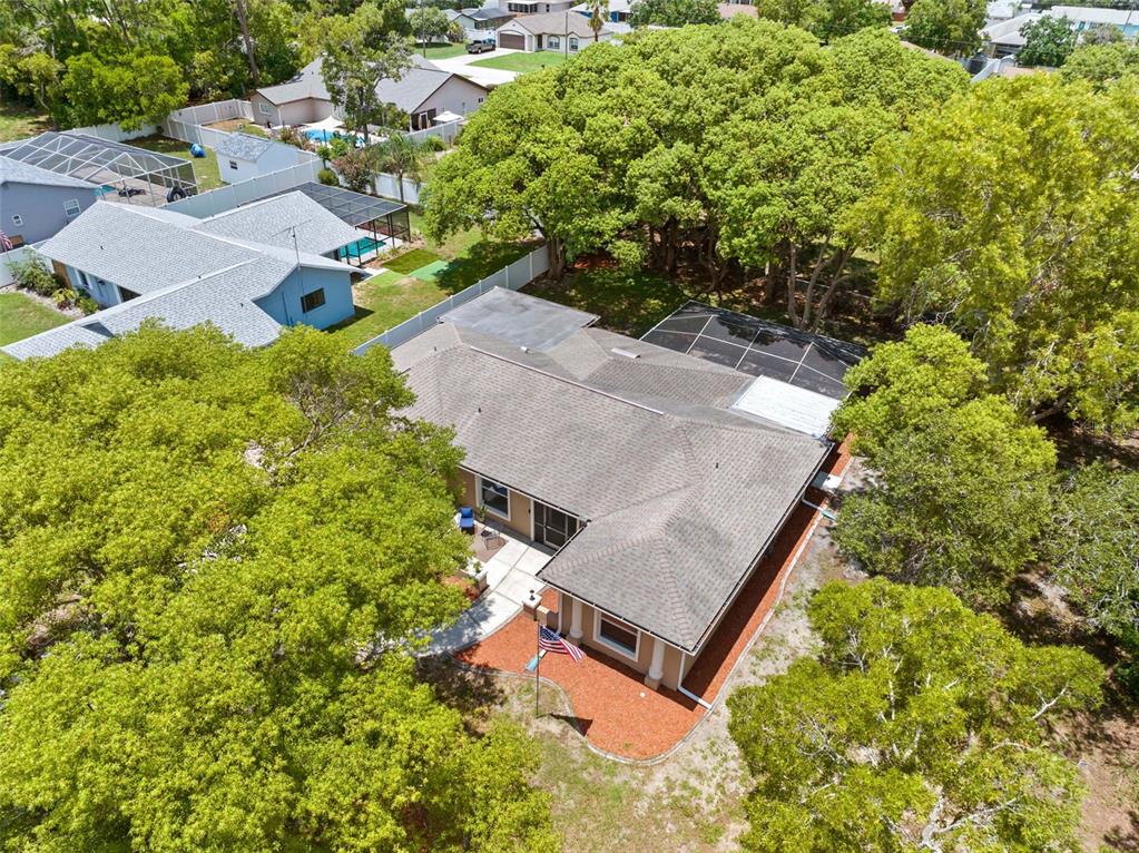An aerial view shows a house with a screened-in patio and a large backyard — 11487 KERRIDALE AVENUE, SPRING HILL, FL