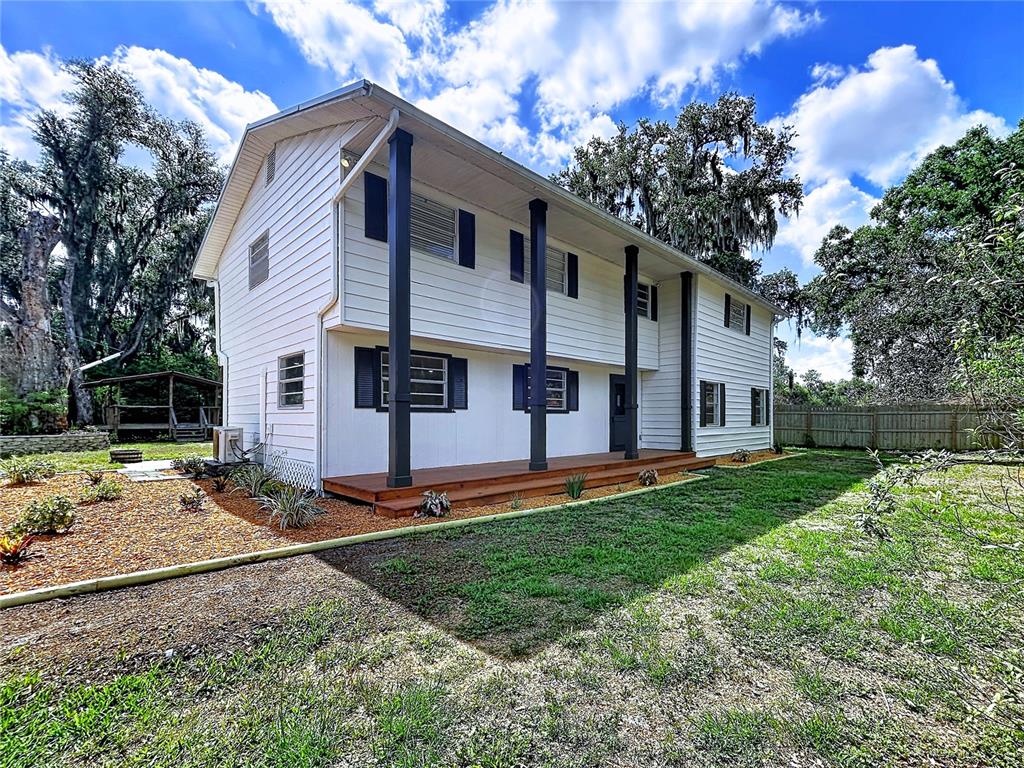 A two-story white house with dark shutters and a wooden front porch — 11008 BROWNING ROAD, LITHIA, FL