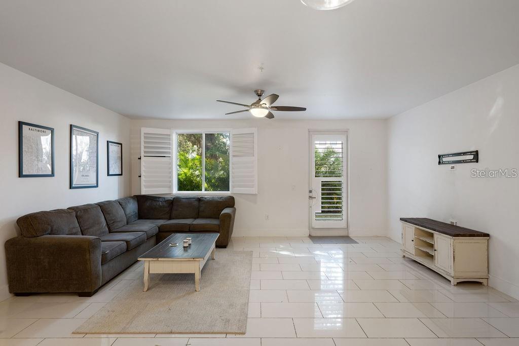 A living room features a gray sectional sofa, a coffee table, and white tile flooring — 432 W SWOOPE AVENUE, WINTER PARK, FL