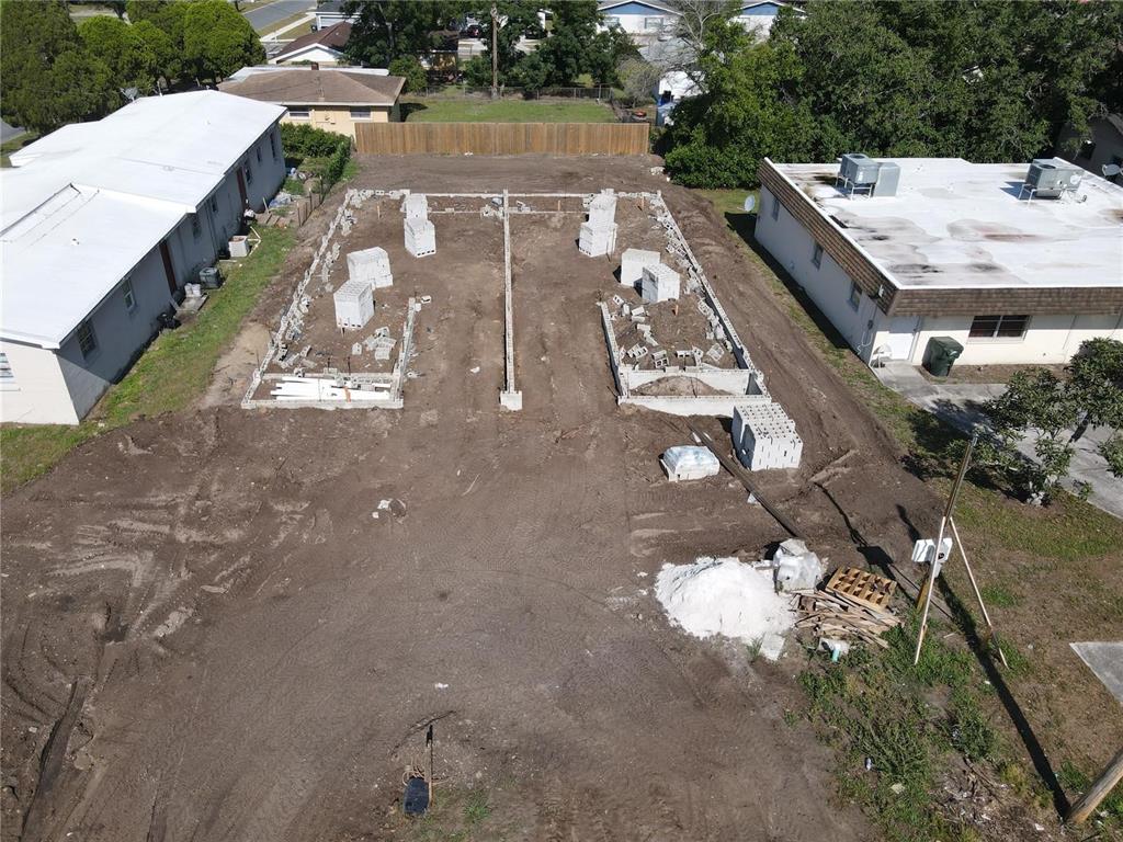 An aerial view shows a construction site with concrete block foundations for a new building — 1108 JEWEL AVENUE, LAKELAND, FL