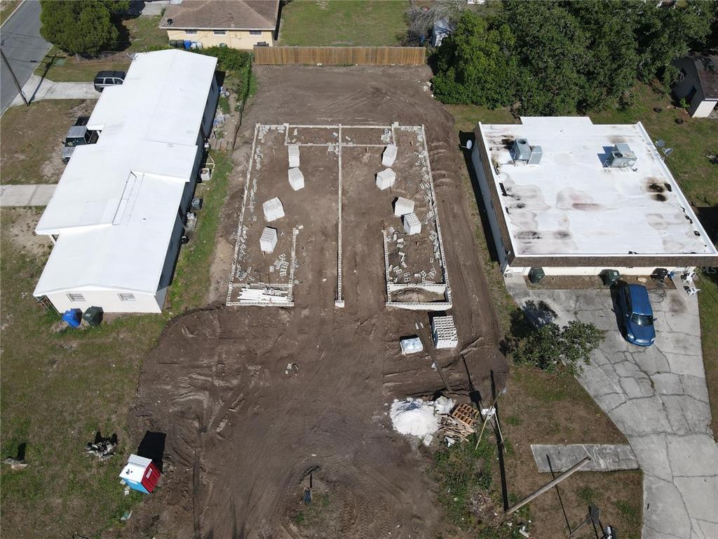 An aerial view shows a vacant lot with a concrete block foundation under construction — 1108 JEWEL AVENUE, LAKELAND, FL