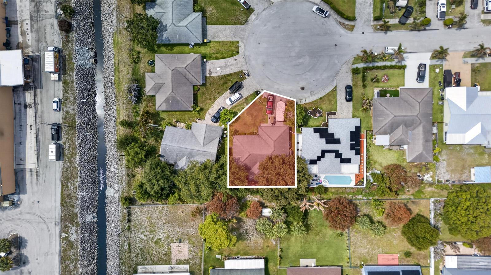 This aerial view shows a residential house with a red roof and a large tree — 706 Osceola Avenue, Fort Pierce FL 34982, FORT PIERCE, FL