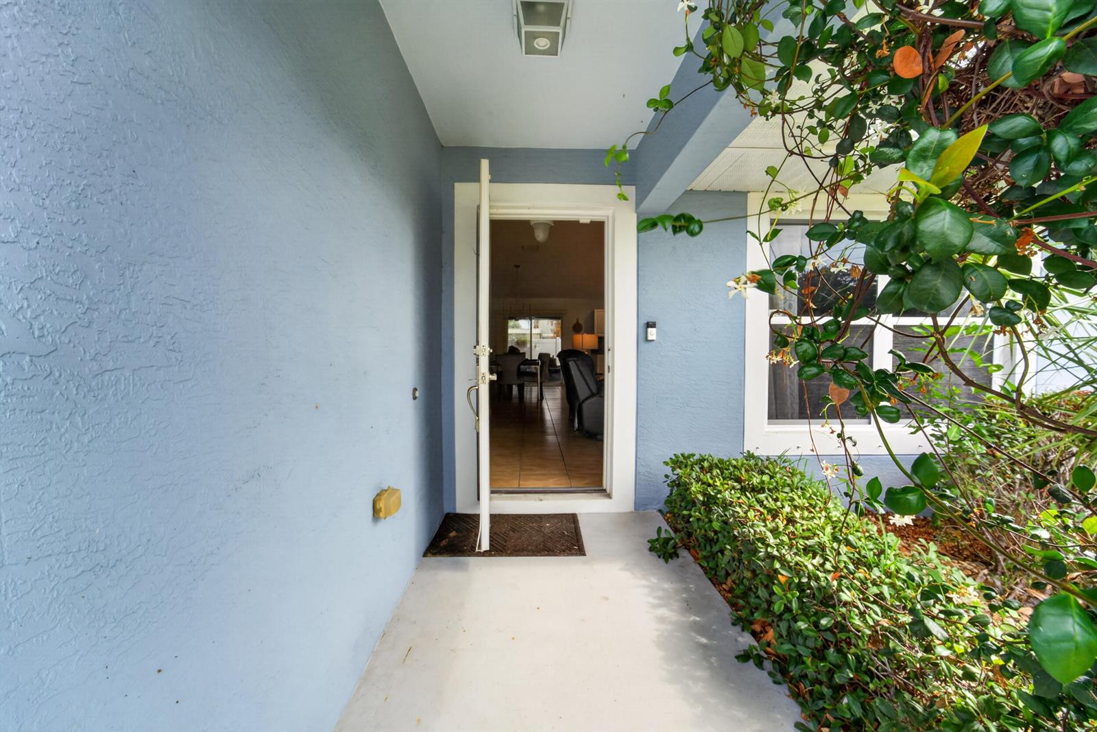 A blue-walled entryway features a front door opening into a home interior with tile flooring — 706 Osceola Avenue, Fort Pierce FL 34982, FORT PIERCE, FL