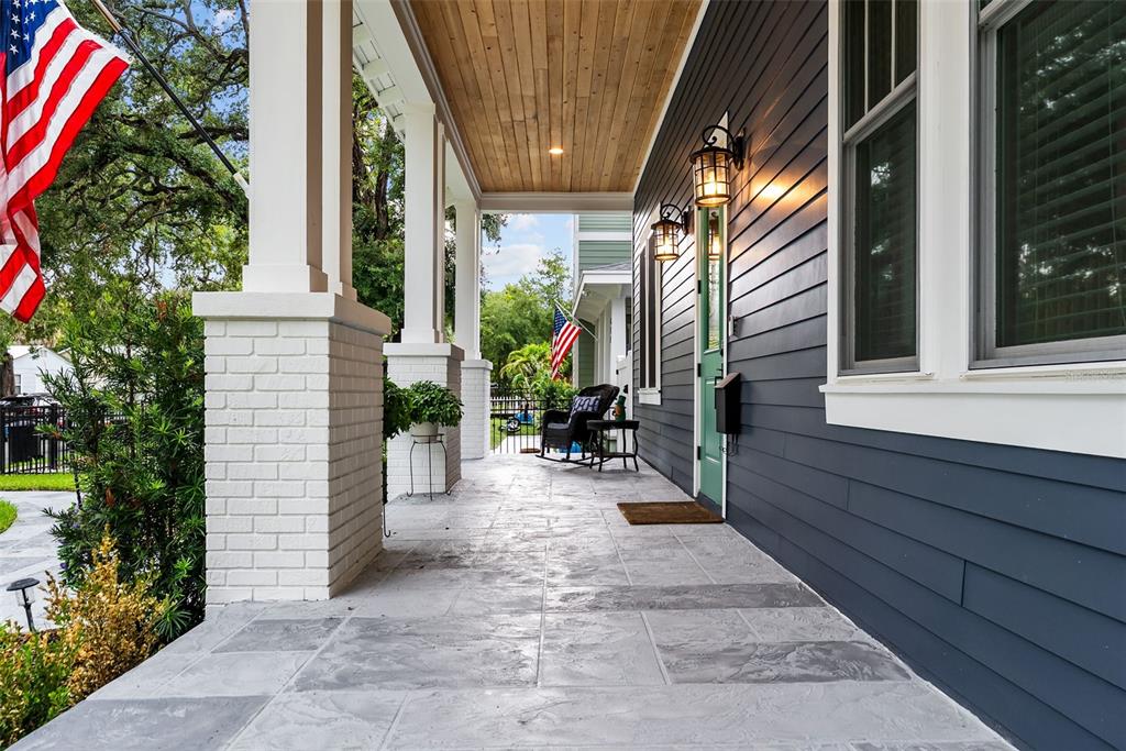 A covered front porch features a wood-paneled ceiling, gray tiled flooring, and dark siding — 607 12TH AVENUE S, ST PETERSBURG, FL