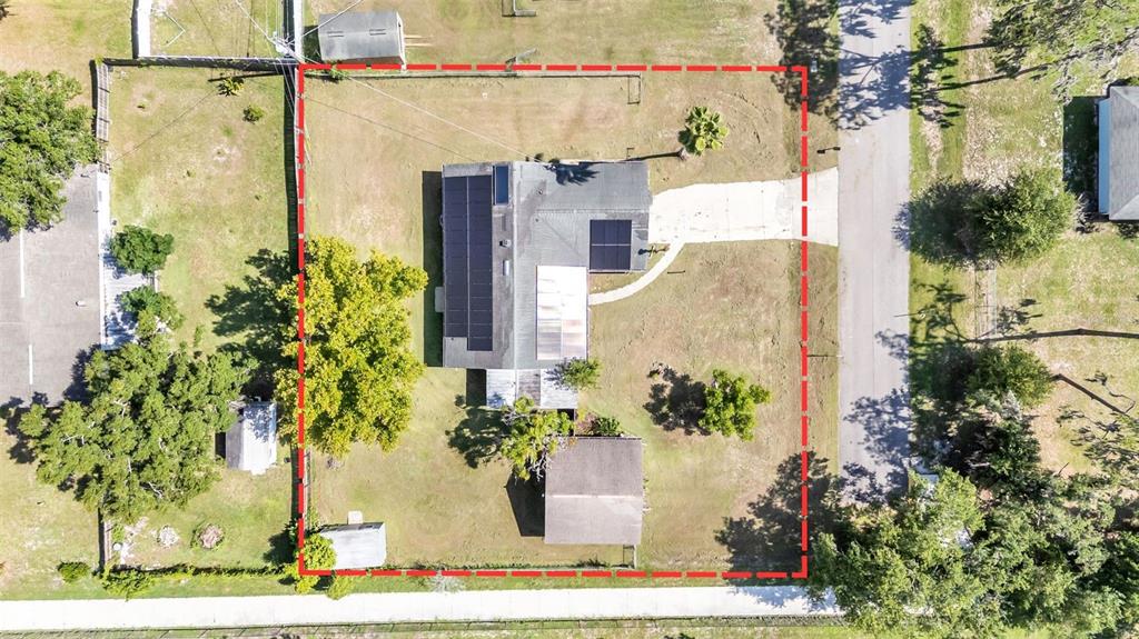 An aerial view shows a house with solar panels on a lot with trees — 5060 STARLING DRIVE, MULBERRY, FL