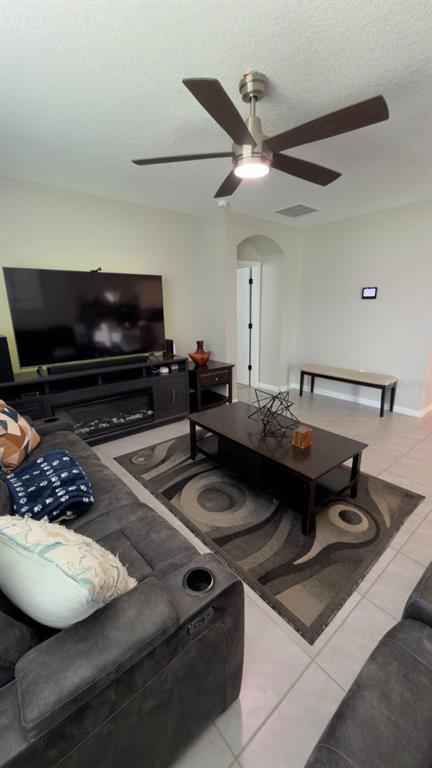 A living room features a dark gray sofa, a coffee table, and a ceiling fan — 1583 BARBERRY DRIVE, KISSIMMEE, FL