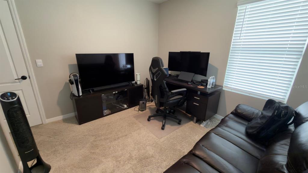 A home office features a desk with a computer, a television, and a leather sofa — 1583 BARBERRY DRIVE, KISSIMMEE, FL