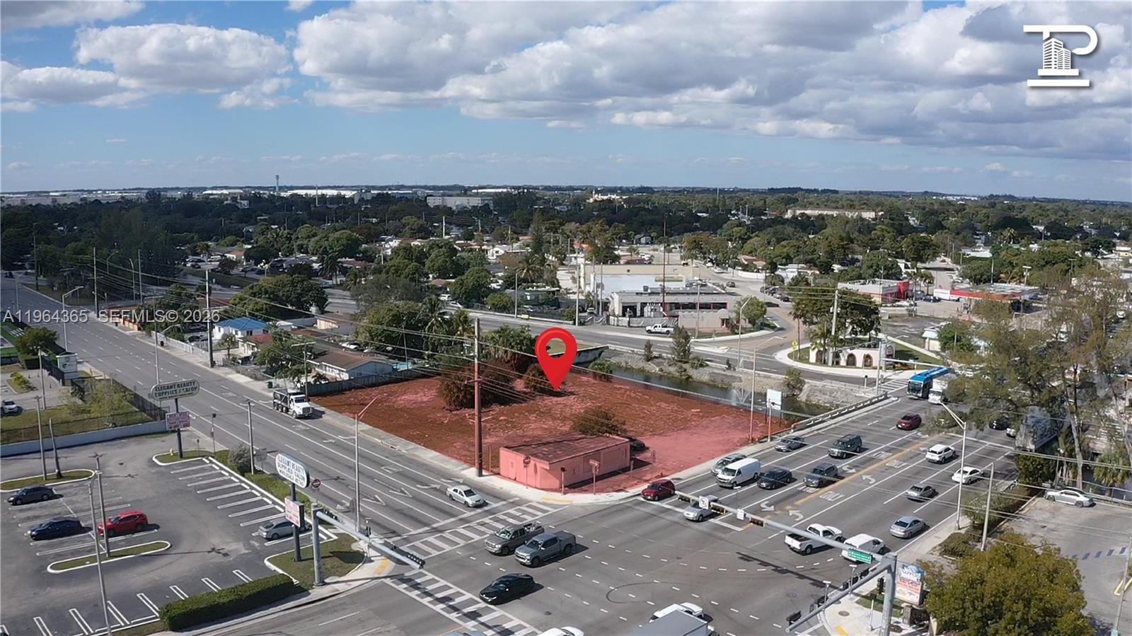 An aerial view shows a vacant, reddish-dirt corner lot with a small structure at an intersection — 13510 NW 27th Ave, Opa-Locka FL 33054, OPA-LOCKA, FL