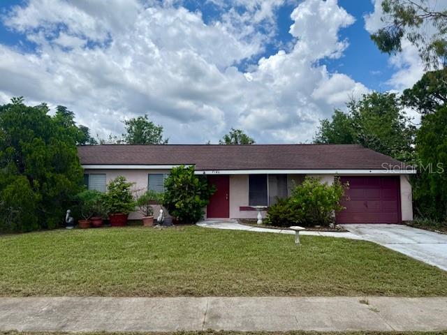 A single-story house with a brown roof, pink exterior, and a red garage door — 7186 GURLEY COURT, NORTH PORT, FL