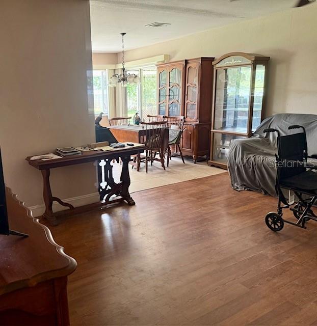 A dining area features wood flooring, a wooden table with chairs, and a glass-fronted cabinet — 7186 GURLEY COURT, NORTH PORT, FL