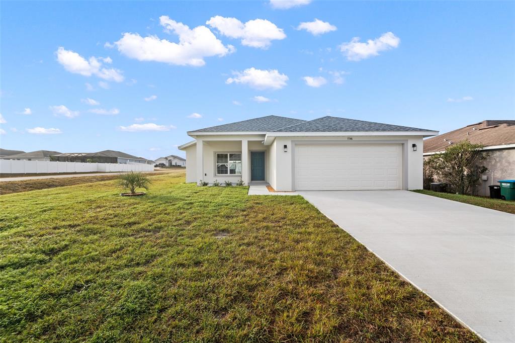 A single-story house with a white exterior, a two-car garage, and a concrete driveway — 5346 SE 91ST STREET, OCALA, FL
