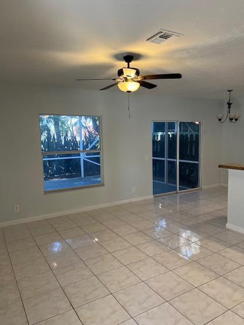 A bright room features light-colored tile flooring, a ceiling fan, and sliding glass patio doors — 140 Baldwin Blvd Boulevard, FL 33463, FL