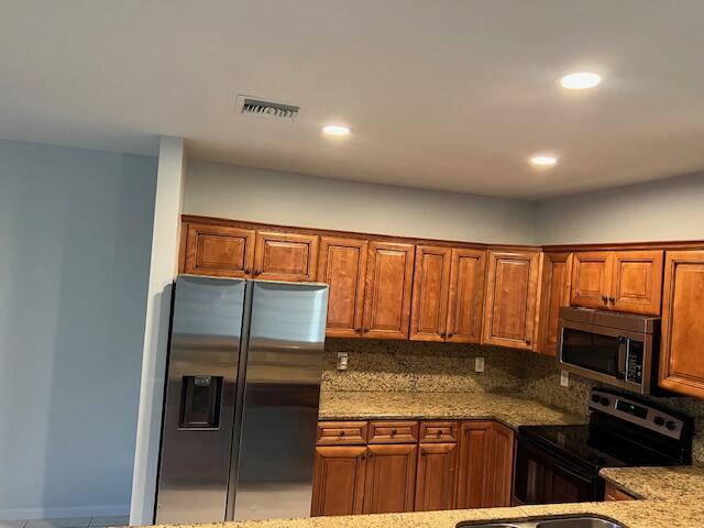A kitchen features wood cabinets, granite countertops, and stainless steel appliances — 140 Baldwin Blvd Boulevard, FL 33463, FL