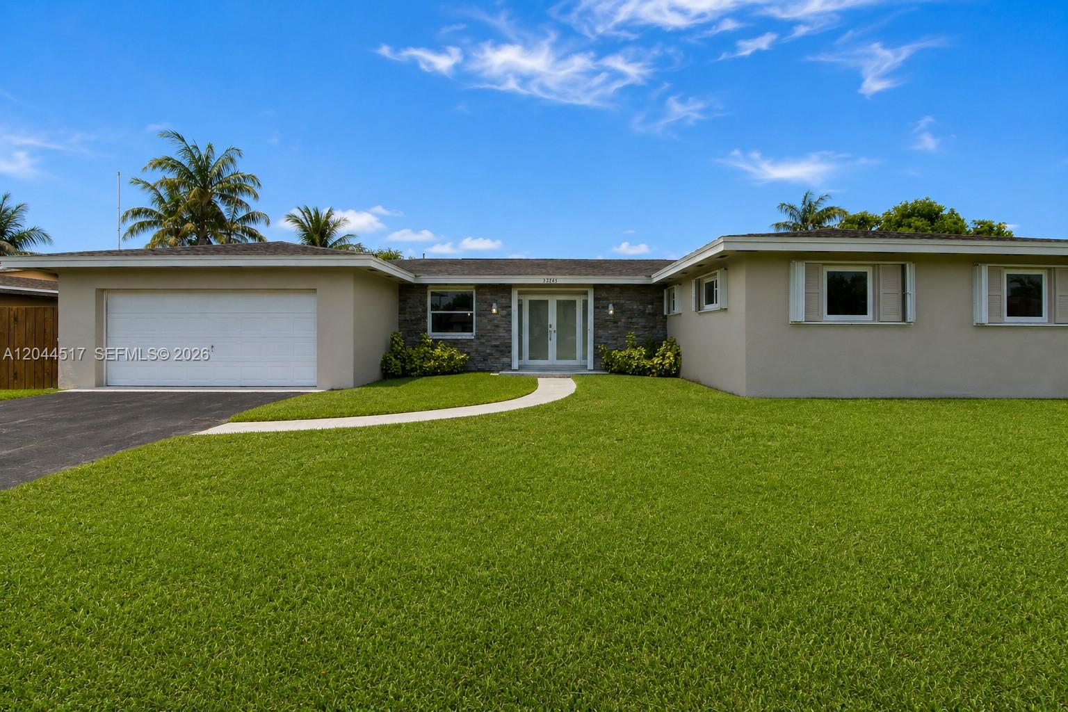 A single-story house with a white garage, stone facade, and a green lawn — 15445 SW 99th Ave # 15445, Miami FL 33157, MIAMI, FL
