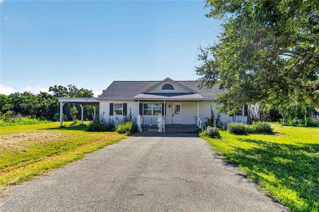 A single-story white house with a covered carport and a paved driveway — 2994 BIG SKY BOULEVARD, KISSIMMEE, FL