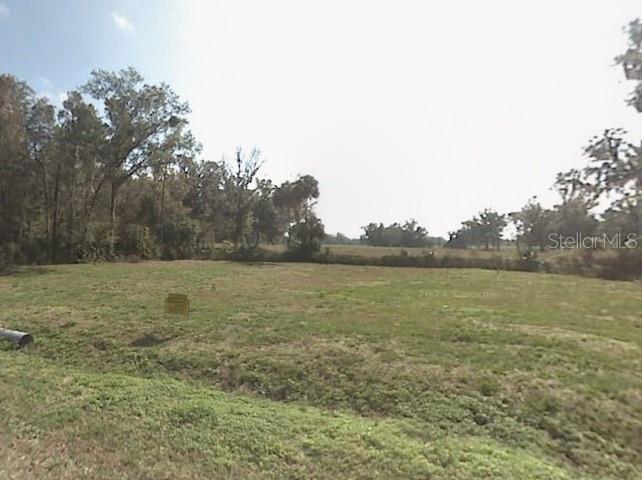 A vacant, grassy lot is bordered by trees under a bright, clear sky — 15 TH 15TH PL, OCALA, FL