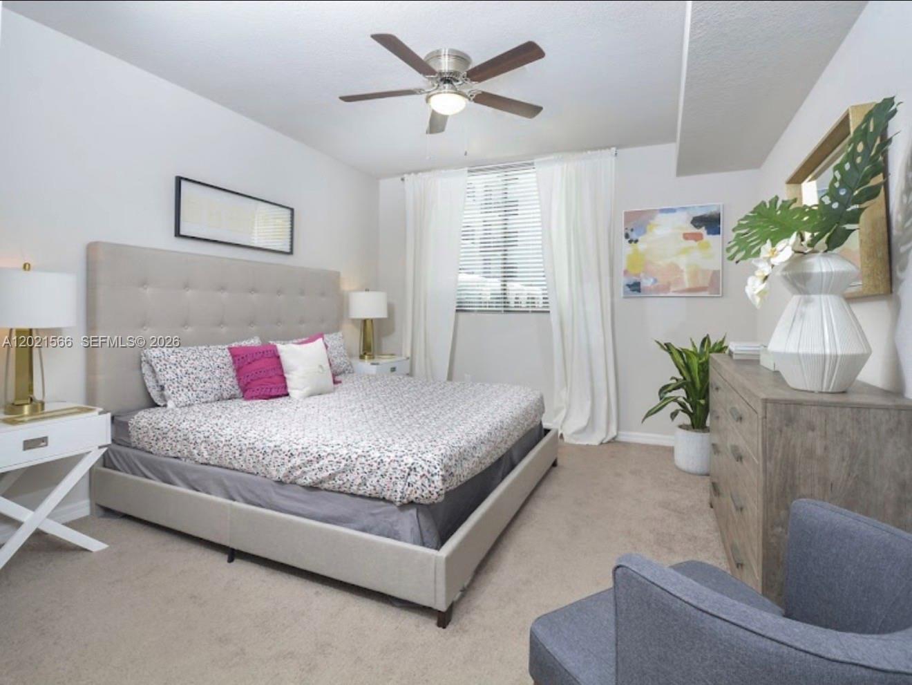 A bedroom features a tufted headboard, a ceiling fan, a dresser, and a gray armchair — 2001 NW 67th St # 110, West Miami FL 33147, WEST MIAMI, FL