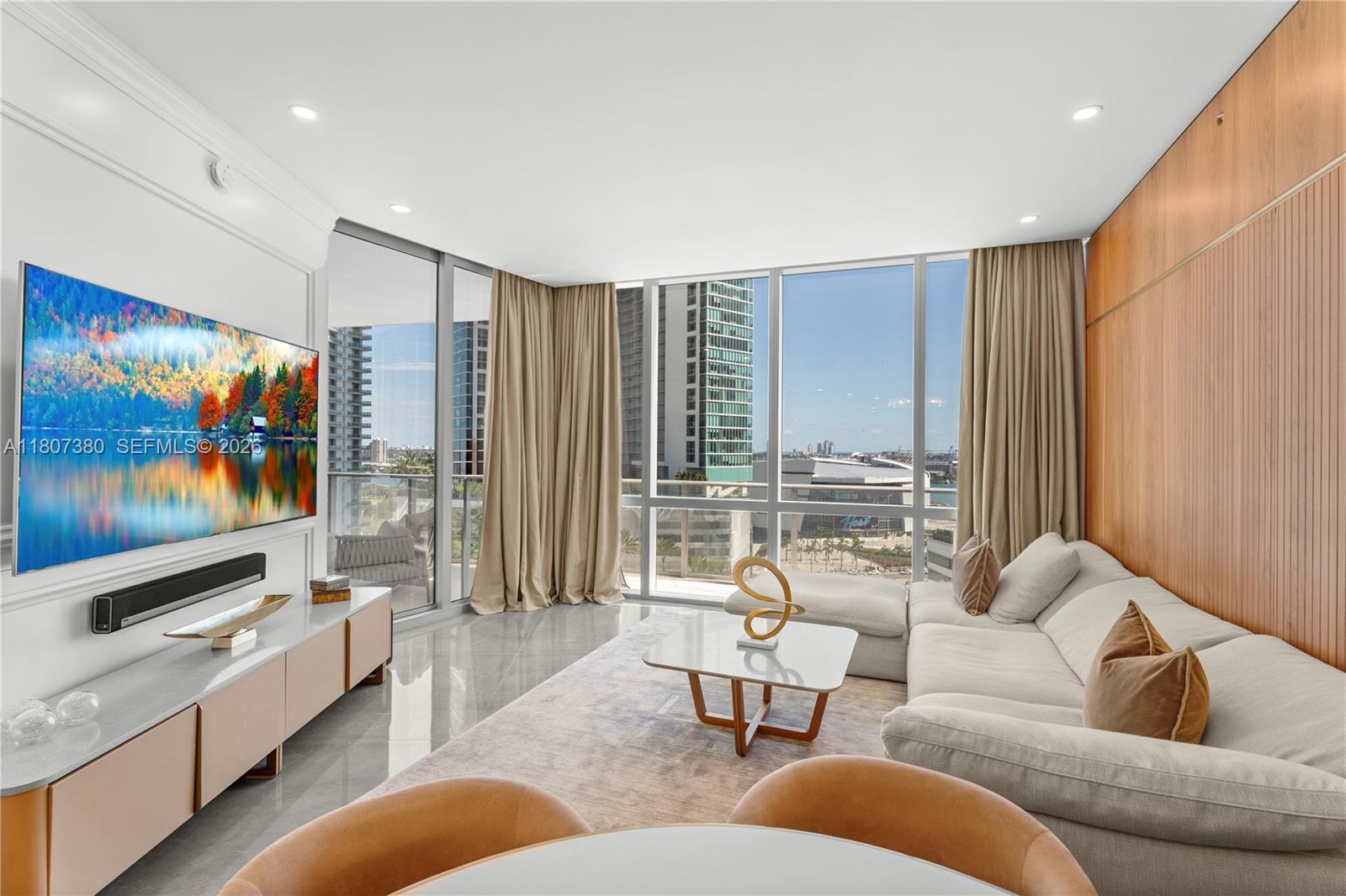 A modern living room features a large television, a sectional sofa, and floor-to-ceiling windows — 851 NE 1st Ave # 1409, Miami FL 33132, MIAMI, FL