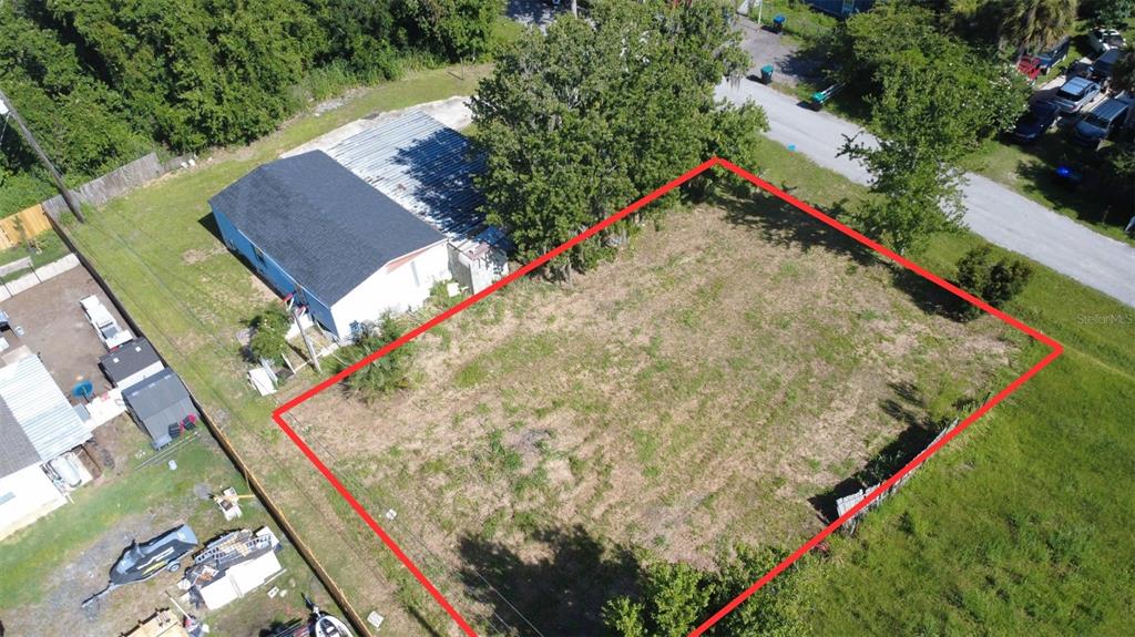 An aerial view shows a vacant rectangular lot outlined in red next to a house — 3RD AVENUE, ORLANDO, FL