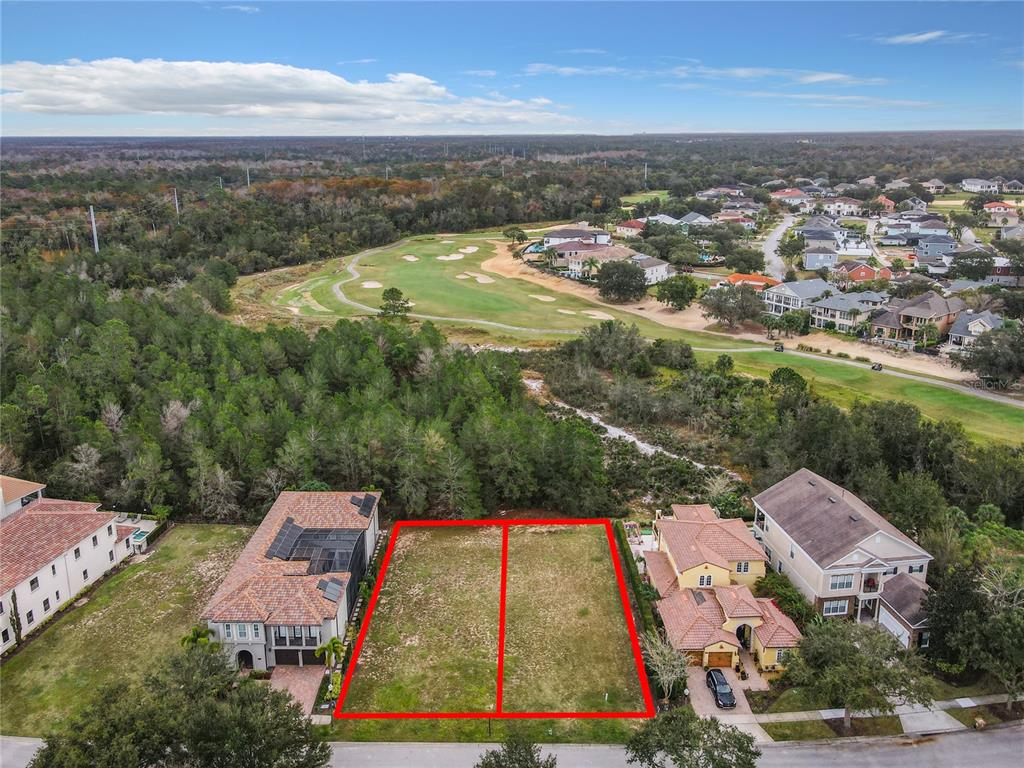 An aerial view shows two adjacent vacant residential lots bordered by houses and a golf course — 1111 WATSON COURT, KISSIMMEE, FL