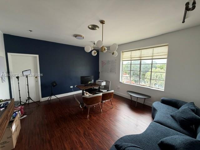 A room features dark wood flooring, a navy accent wall, a chandelier, and a blue sofa — 7100 Biscayne Blvd # 305, Miami FL 33138, MIAMI, FL