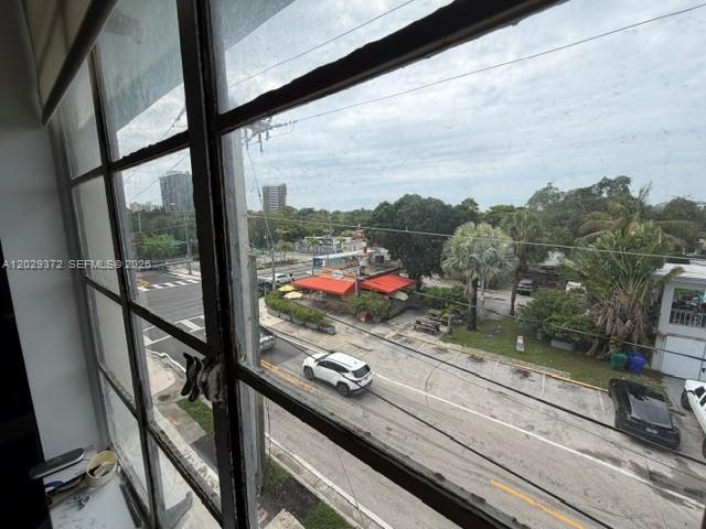 A view from a window overlooking a street, parking lot, and surrounding trees and buildings — 7100 Biscayne Blvd # 305, Miami FL 33138, MIAMI, FL