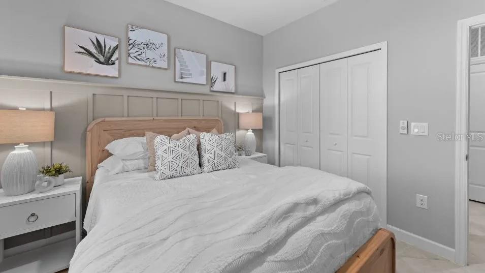 A bedroom features a wooden bed frame, board and batten wall paneling, and white bedding — 8462 WATER LILY COURT, ENGLEWOOD, FL