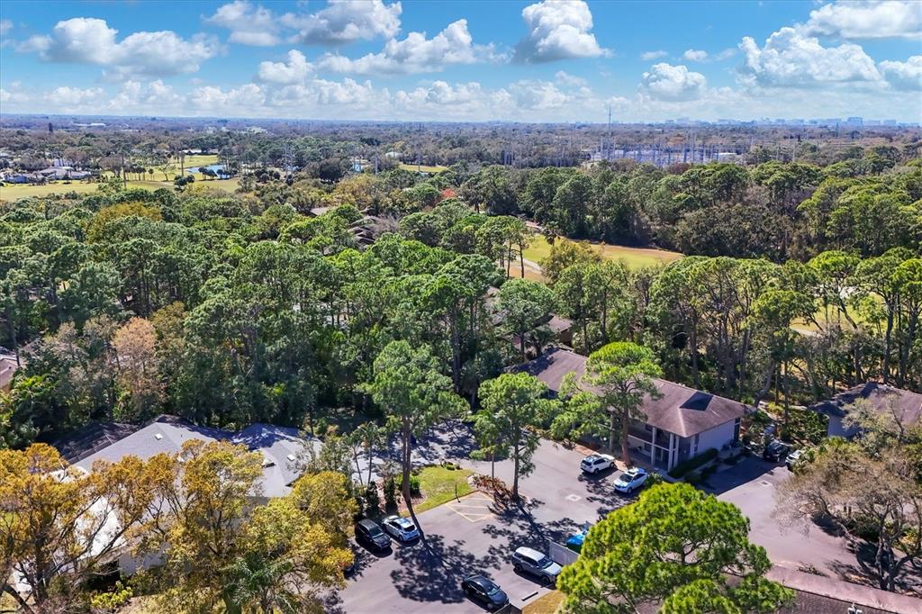 An aerial view shows a parking lot surrounded by trees and residential buildings — 3041 QUAIL HOLLOW UNIT 27, SARASOTA, FL