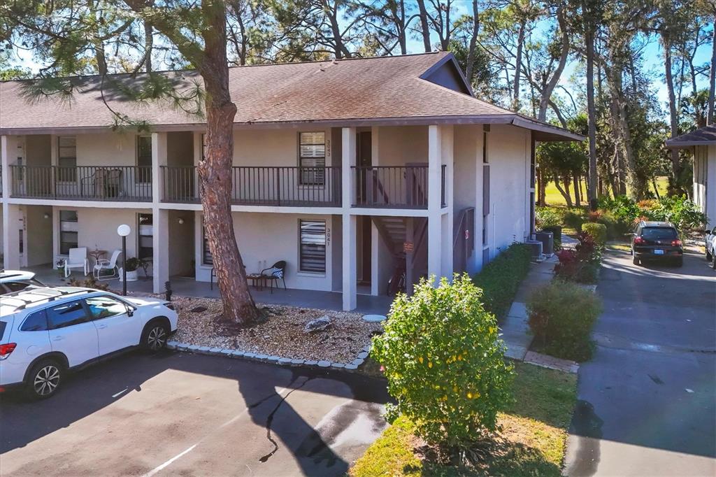 An exterior view of a two-story apartment building with balconies and a parking lot — 3041 QUAIL HOLLOW UNIT 27, SARASOTA, FL