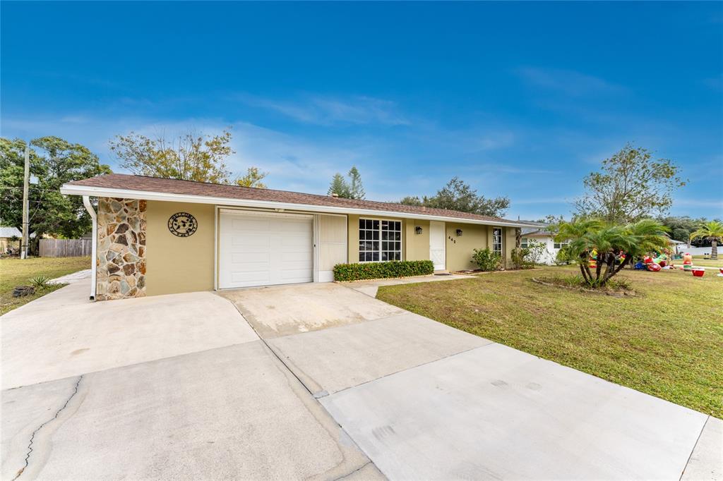 A single-story house with a stone-accented corner, a white garage door, and a concrete driveway — 442 KOSTNER STREET, PORT CHARLOTTE, FL