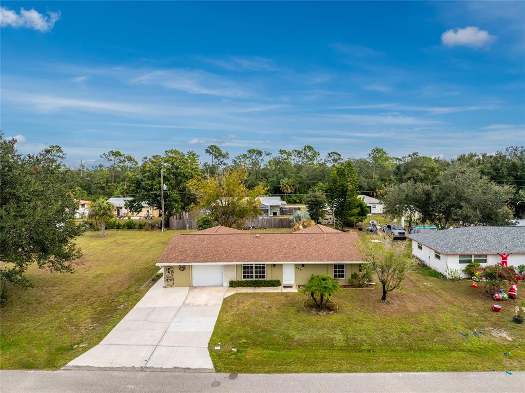 An aerial view shows a single-story house with a brown roof and a concrete driveway — 442 KOSTNER STREET, PORT CHARLOTTE, FL
