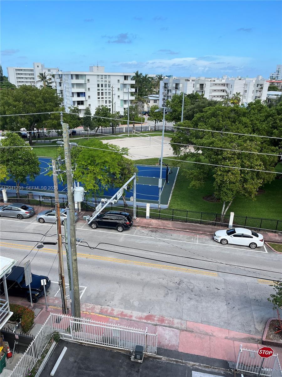 An elevated view shows a street with parked cars, a basketball court, and apartment buildings — 8024 Tatum Waterway Dr # 6B, Miami Beach FL 33141, MIAMI BEACH, FL