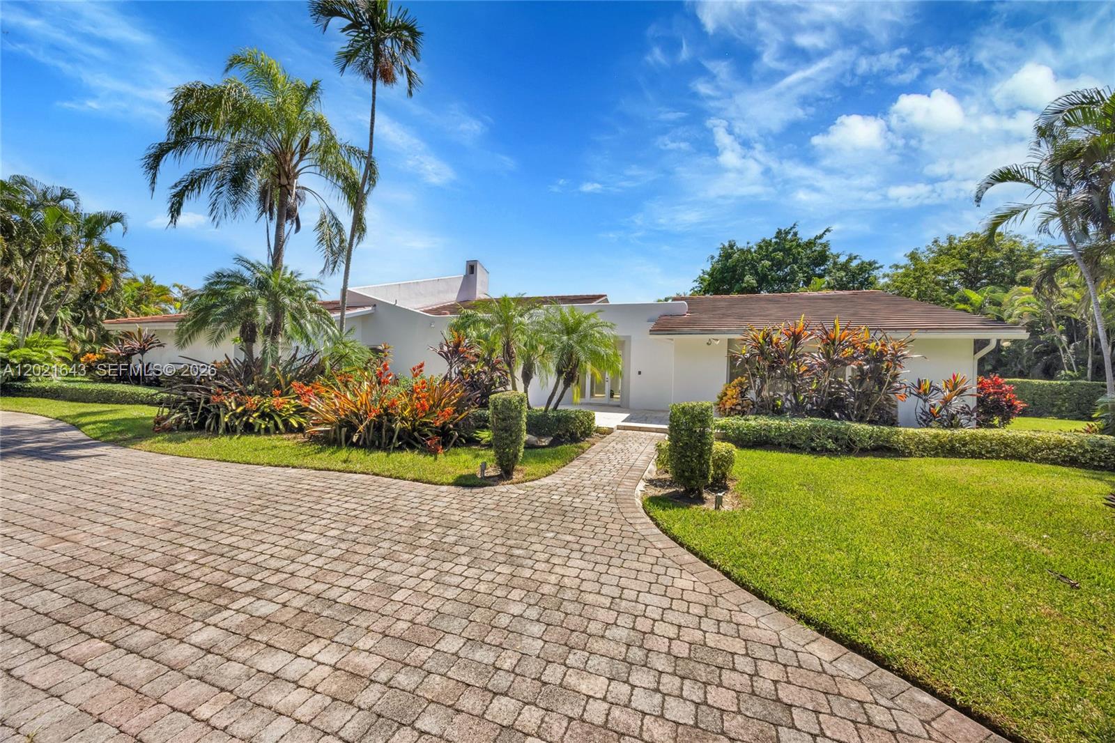 A white single-story house features a paved driveway, tropical landscaping, and a tiled roof — 8303 Old Cutler Rd, Coral Gables FL 33143, CORAL GABLES, FL