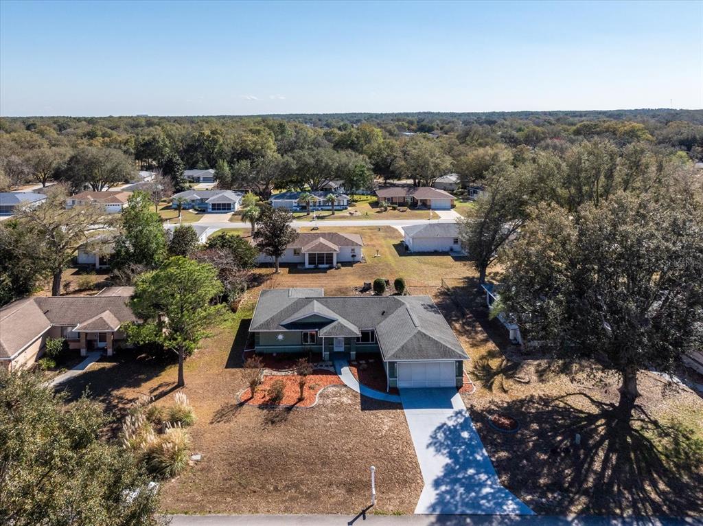An aerial view shows a single-story house with a gray roof and a concrete driveway — 6114 SW 104TH STREET, OCALA, FL