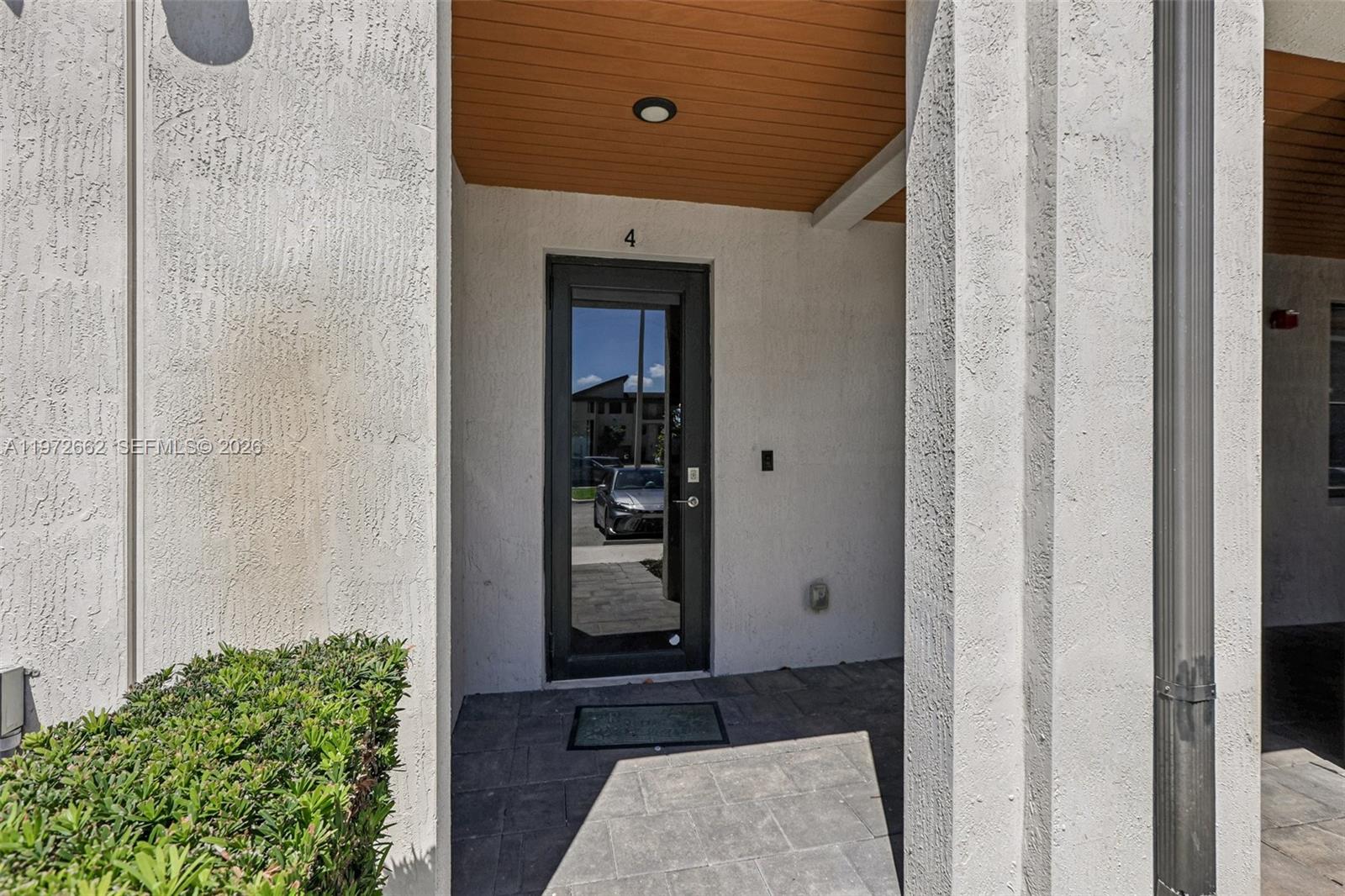 A glass-paneled front door marked with the number four sits under a covered entryway — 10455 NW 82nd St # 4, Doral FL 33178, DORAL, FL