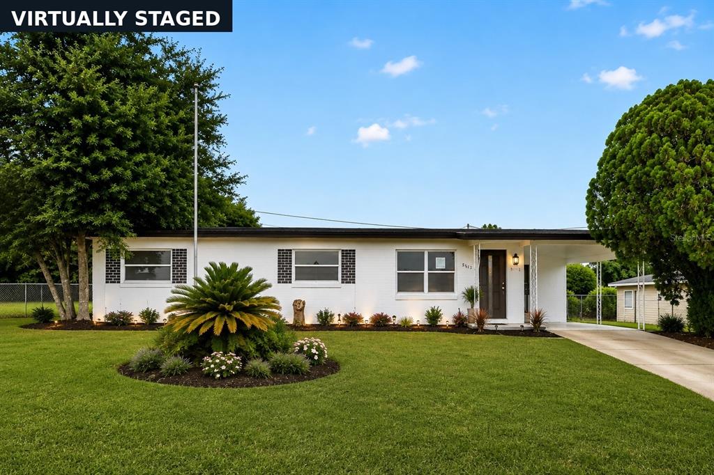 A single-story white house with a carport and a landscaped front yard — 3413 PARIS PLACE, ORLANDO, FL