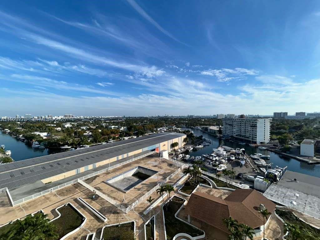An elevated view shows a marina, a large warehouse, and a pool deck under blue skies — 13499 Biscayne Blvd # 1206, North Miami FL 33181, NORTH MIAMI, FL