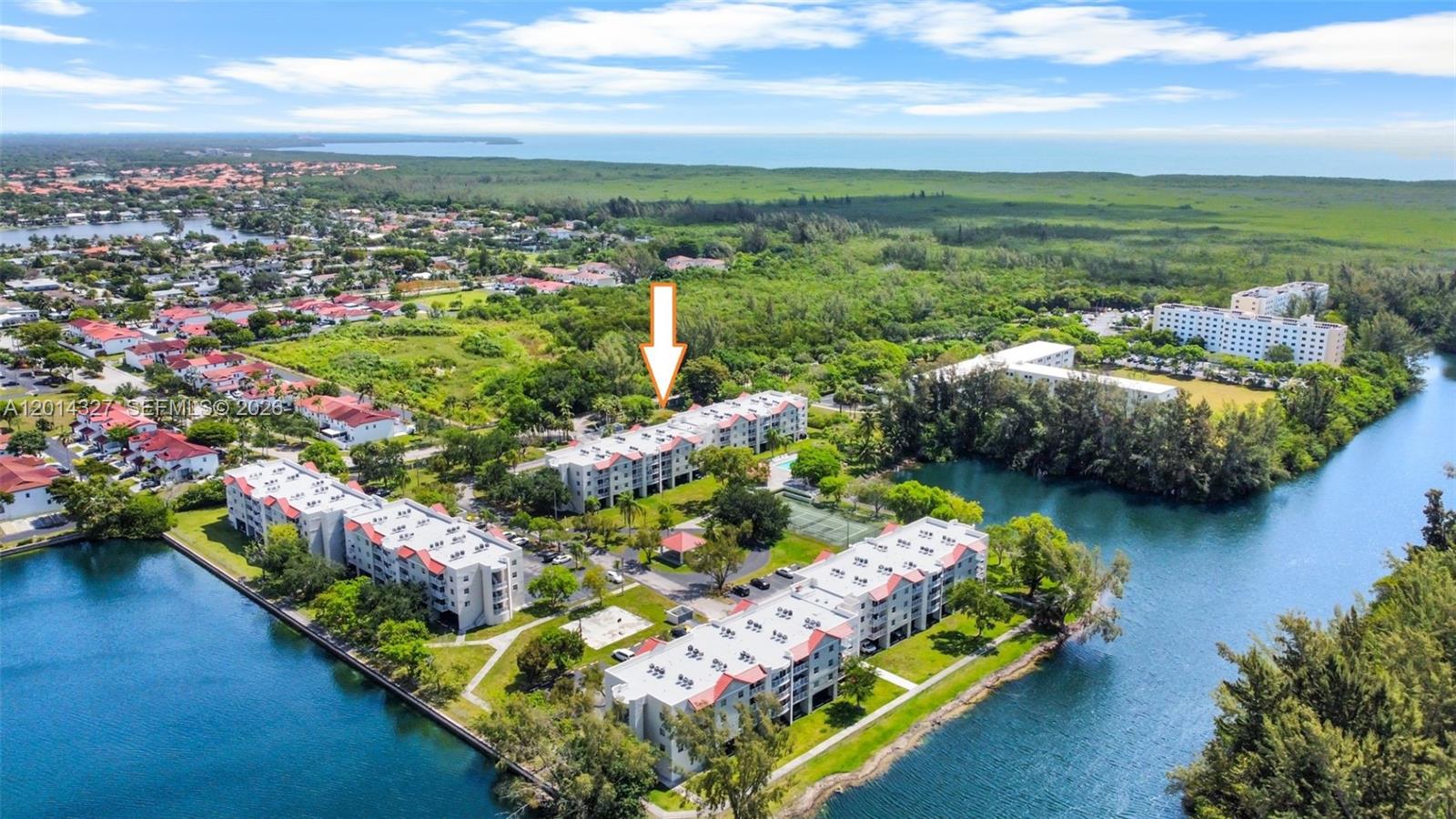 An aerial view shows several multi-story apartment buildings surrounded by water and green space — 8200 SW 210th St # 103, Cutler Bay FL 33189, CUTLER BAY, FL