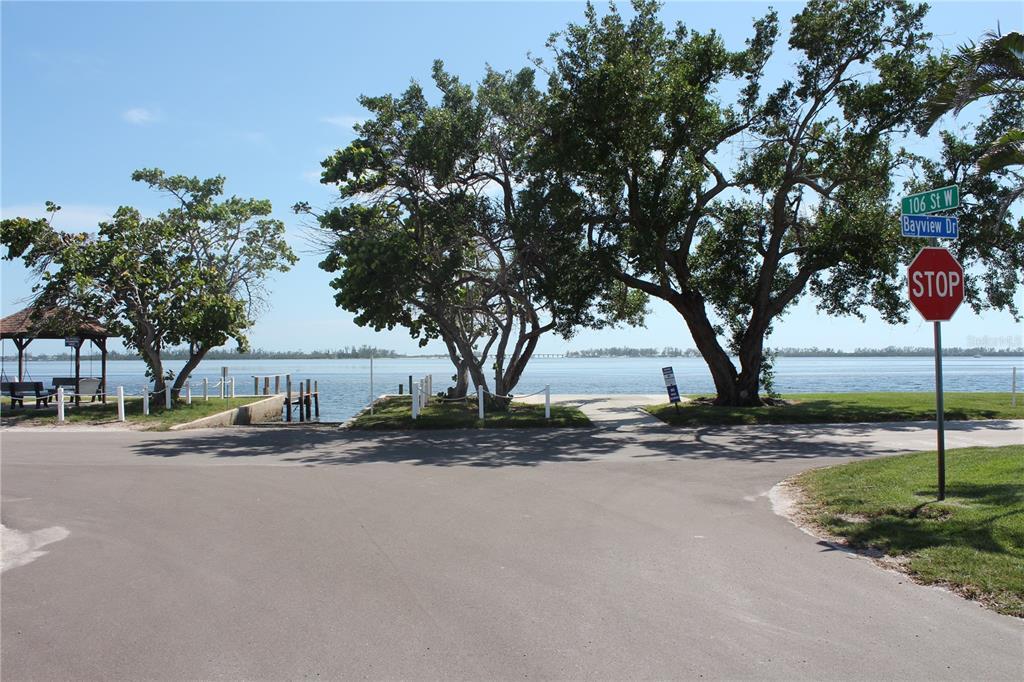 A paved road leads to a waterfront area with trees, a gazebo, and a stop sign — 10315 CORTEZ ROAD W UNIT 1/2 BV, BRADENTON, FL