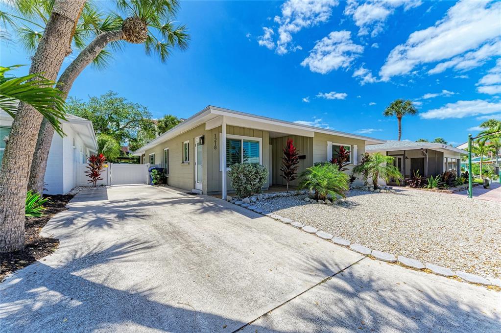 A single-story house with a concrete driveway, gravel front yard, and palm trees — 1218 MOONMIST CIRCLE UNIT S2, SARASOTA, FL