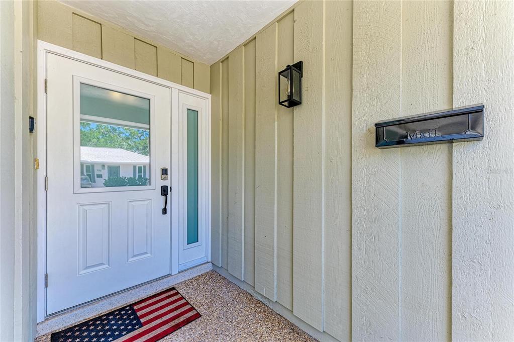 A white front door with a side light and a wall-mounted mailbox on a porch — 1218 MOONMIST CIRCLE UNIT S2, SARASOTA, FL