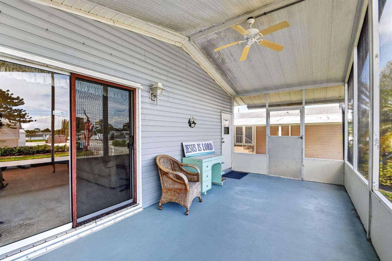 A screened-in porch features a blue painted floor, a ceiling fan, and a wicker chair — 4290 Meadow View Drive, Boynton Beach FL 33436, BOYNTON BEACH, FL