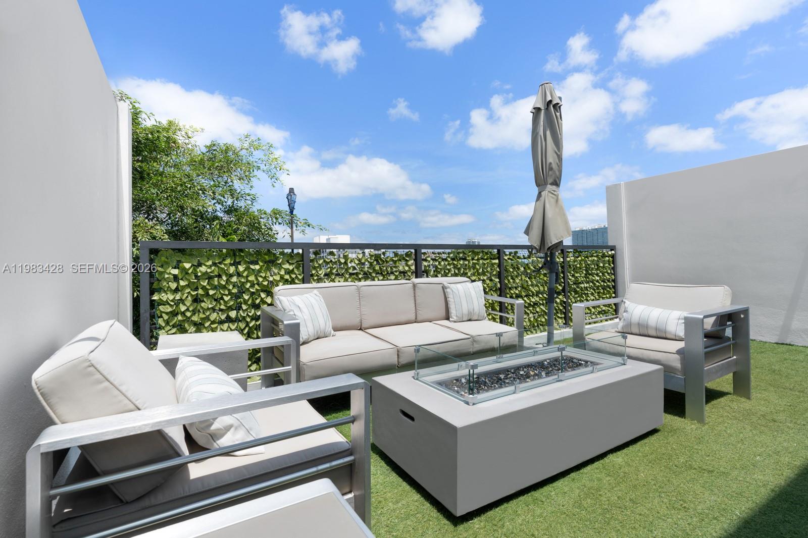 A rooftop patio features outdoor furniture, a fire pit, and a green privacy screen — 1065 99th St, Bay Harbor Islands FL 33154, BAY HARBOR ISLANDS, FL
