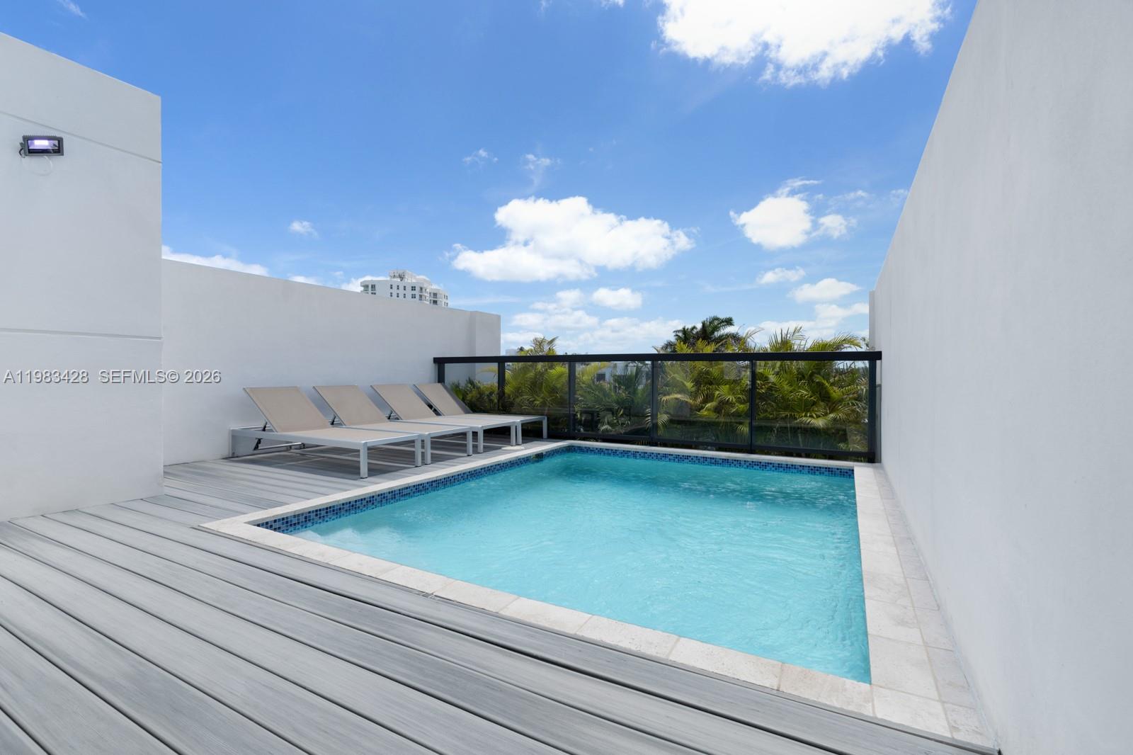 A rooftop terrace features a small swimming pool, four lounge chairs, and a glass railing — 1065 99th St, Bay Harbor Islands FL 33154, BAY HARBOR ISLANDS, FL